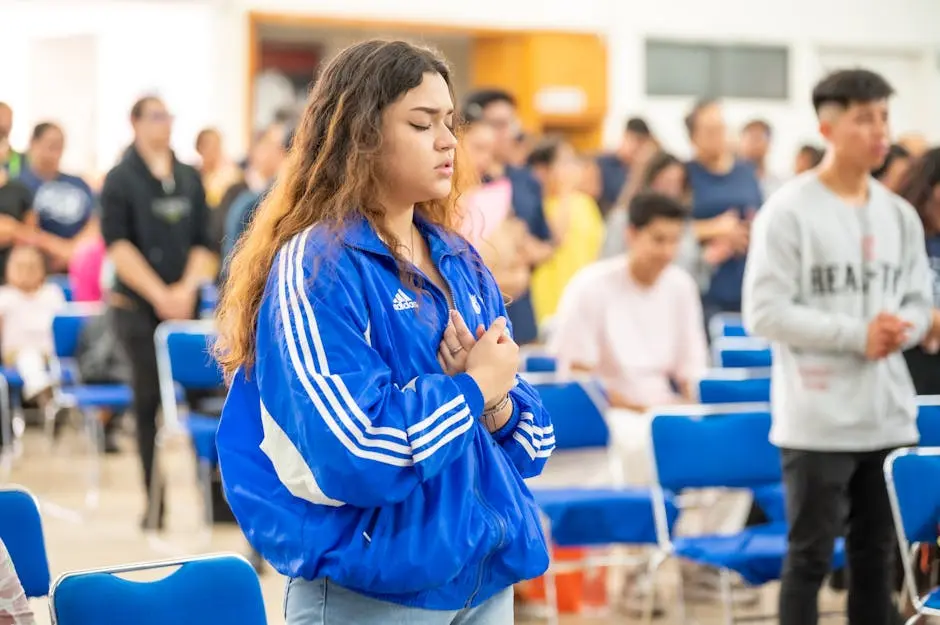 A young woman in blue jacket and blue jeans is praying